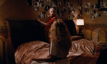 Movie still from “The Comfort of Strangers” (1990), directed by Paul Schrader – Two women sitting on a bed in front of a lamp; Wide shot, Over the shoulder angle