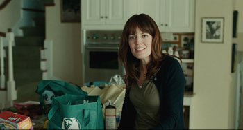 Movie still from “The Company Men” (2010), directed by John Wells – A woman sitting at a table in front of a bag; Medium shot, Over the shoulder angle