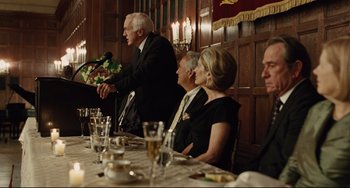 Movie still from “The Company Men” (2010), directed by John Wells – A group of people sitting at a dinner table; Medium shot, Over the shoulder angle