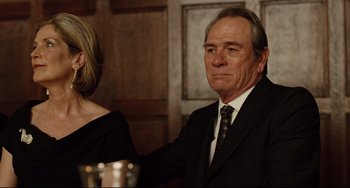 Movie still from “The Company Men” (2010), directed by John Wells – An older man in a suit and tie next to a woman in a black dress; Close Up shot, Over the shoulder angle