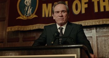 Movie still from “The Company Men” (2010), directed by John Wells – A man in a suit standing at a podium; Close Up shot, Low angle