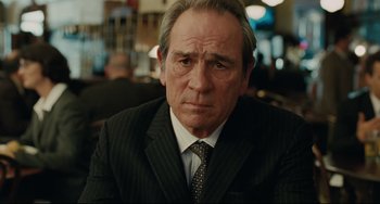 Movie still from “The Company Men” (2010), directed by John Wells – An older man wearing a suit and tie in a restaurant; Close Up shot, Low angle