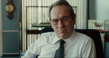 Movie still from “The Company Men” (2010), directed by John Wells – An older man in a white shirt and a tie; Close Up shot, Over the shoulder angle