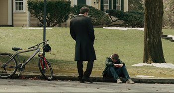 Movie still from “The Company Men” (2010), directed by John Wells – Two men sitting on the side of the street; Wide shot, Over the shoulder angle