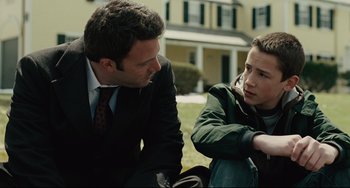Movie still from “The Company Men” (2010), directed by John Wells – A man in a suit talking to a boy in a jacket; Medium shot, Over the shoulder angle