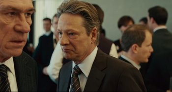 Movie still from “The Company Men” (2010), directed by John Wells – An older man in a suit and tie looking sad; Close Up shot, Over the shoulder angle