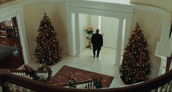 Movie still from “The Company Men” (2010), directed by John Wells – An older man walking through a doorway to a christmas tree; Wide shot, Low angle