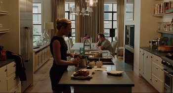 Movie still from “The Company Men” (2010), directed by John Wells – A woman standing in front of a man in a kitchen; Wide shot, Over the shoulder angle