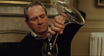 Movie still from “The Company Men” (2010), directed by John Wells – A man pouring wine into a wine glass; Close Up shot, Low angle