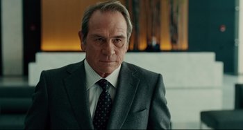 Movie still from “The Company Men” (2010), directed by John Wells – An older man in a suit and tie looking at the camera; Close Up shot, Over the shoulder angle