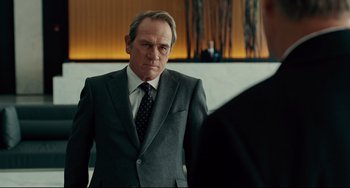 Movie still from “The Company Men” (2010), directed by John Wells – A man in a suit and tie standing in front of a mirror; Medium shot, Over the shoulder angle