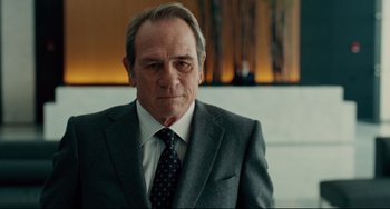 Movie still from “The Company Men” (2010), directed by John Wells – An older man in a suit and tie looking at the camera; Close Up shot, Low angle