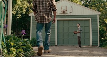 Movie still from “The Company Men” (2010), directed by John Wells – Two men are playing basketball in a driveway; Wide shot, Over the shoulder angle
