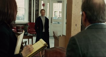 Movie still from “The Company Men” (2010), directed by John Wells – A woman standing in front of an open door; Medium shot, Over the shoulder angle