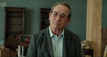 Movie still from “The Company Men” (2010), directed by John Wells – An older man wearing a suit and glasses; Close Up shot, Over the shoulder angle