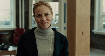 Movie still from “The Company Men” (2010), directed by John Wells – A woman wearing a gray sweater and a black jacket; Close Up shot, Over the shoulder angle