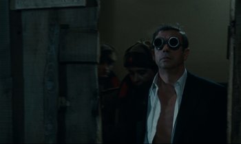 Movie still from “The Confession” (1970), directed by Costa-Gavras – A man wearing a pair of goggles and a tie; Medium shot, Low angle