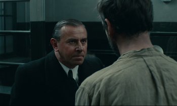 Movie still from “The Confession” (1970), directed by Costa-Gavras – A man looking at himself in the mirror in front of a mirror; Close Up shot, Over the shoulder angle