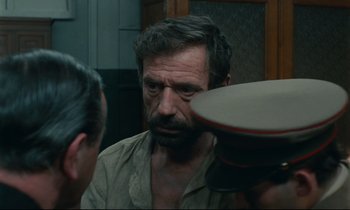 Movie still from “The Confession” (1970), directed by Costa-Gavras – A man with a beard is looking in the mirror; Close Up shot, Over the shoulder angle