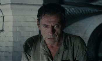 Movie still from “The Confession” (1970), directed by Costa-Gavras – An older man is looking at the camera; Close Up shot, High angle