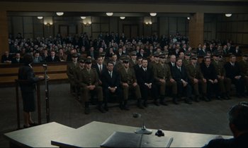 Movie still from “The Confession” (1970), directed by Costa-Gavras – A group of men sitting in front of an audience; Extreme Wide shot, High angle