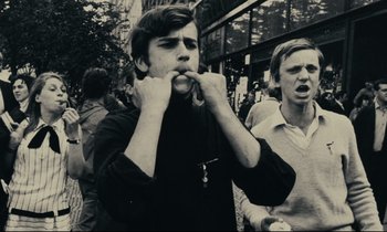 Movie still from “The Confession” (1970), directed by Costa-Gavras – A young man with his mouth open in the middle of the street; Medium shot, Low angle