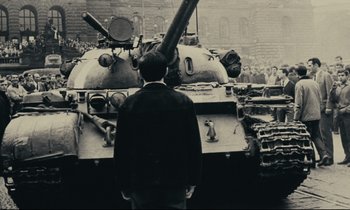 Movie still from “The Confession” (1970), directed by Costa-Gavras – A man standing in front of a tank in a crowd; Medium shot, Low angle