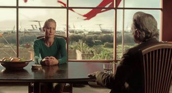 Movie still from “The Congress” (2013), directed by Ari Folman – A woman sitting at a table in front of an airplane window; Medium shot, Over the shoulder angle