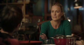 Movie still from “The Congress” (2013), directed by Ari Folman – A woman sitting at a table with her arms crossed; Close Up shot, Over the shoulder angle