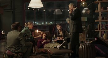 Movie still from “The Congress” (2013), directed by Ari Folman – A group of people sitting around a living room at night; Wide shot, High angle