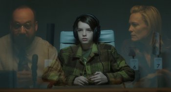 Movie still from “The Congress” (2013), directed by Ari Folman – A person wearing headphones sitting in a chair; Close Up shot, Over the shoulder angle