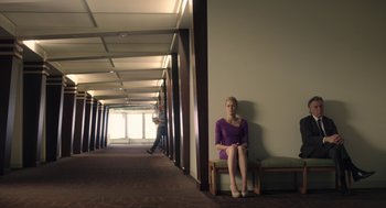 Movie still from “The Congress” (2013), directed by Ari Folman – A woman sitting on top of a chair in a room; Wide shot, Low angle