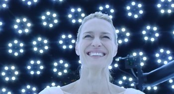 Movie still from “The Congress” (2013), directed by Ari Folman – A woman smiles brightly in front of a wall of lights; Close Up shot, Low angle