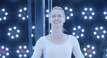 Movie still from “The Congress” (2013), directed by Ari Folman – A woman standing in front of a stage with lights in the background; Medium shot, Low angle