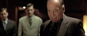 Movie still from “The Cooler” (2003), directed by Wayne Kramer – A man in a suit and tie standing next to another man in a suit and tie; Close Up shot, Over the shoulder angle