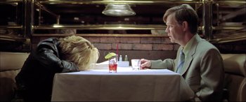 Movie still from “The Cooler” (2003), directed by Wayne Kramer – A man and a woman sitting at a table with drinks; Medium shot, Overhead angle