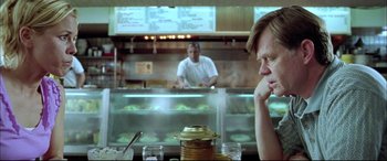 Movie still from “The Cooler” (2003), directed by Wayne Kramer – A man sitting at a table in front of a man behind a counter; Medium shot, Over the shoulder angle