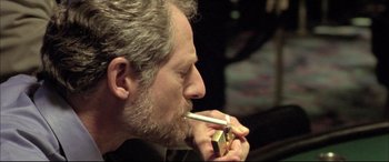 Movie still from “The Cooler” (2003), directed by Wayne Kramer – A person smoking a cigarette; Close Up shot, High angle