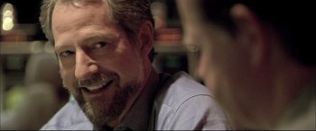 Movie still from “The Cooler” (2003), directed by Wayne Kramer – A man smiling at the camera; Close Up shot, Over the shoulder angle