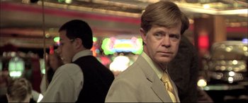 Movie still from “The Cooler” (2003), directed by Wayne Kramer – A man in a suit and tie standing in front of another man in a suit and tie; Close Up shot, Over the shoulder angle