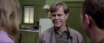 Movie still from “The Cooler” (2003), directed by Wayne Kramer – A person wearing a jacket and smiling; Close Up shot, Over the shoulder angle