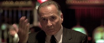 Movie still from “The Cooler” (2003), directed by Wayne Kramer – An older man wearing a suit and tie; Close Up shot, Low angle