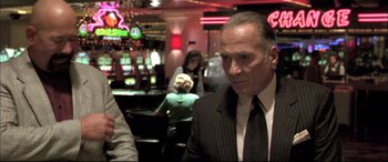 Movie still from “The Cooler” (2003), directed by Wayne Kramer – A man in a suit and tie in front of a bar; Medium shot, Over the shoulder angle