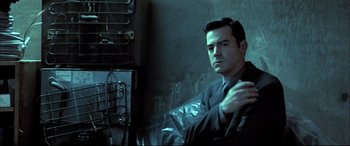 Movie still from “The Cooler” (2003), directed by Wayne Kramer – A man sitting in a chair in front of an oven; Medium shot, Low angle