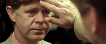 Movie still from “The Cooler” (2003), directed by Wayne Kramer – An older man looking at the camera with one hand on his forehead; Extreme Close Up shot, Over the shoulder angle