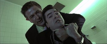 Movie still from “The Cooler” (2003), directed by Wayne Kramer – Two men in suits and one has his hands on the neck of the other man; Close Up shot, Low angle