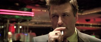 Movie still from “The Cooler” (2003), directed by Wayne Kramer – A person wearing a suit and smoking a cigarette; Close Up shot, Low angle