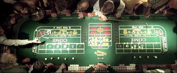 Movie still from “The Cooler” (2003), directed by Wayne Kramer – A group of people standing around a craps table; Extreme Close Up shot, Overhead angle