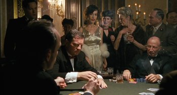 Movie still from “The Counterfeiters” (2007), directed by Stefan Ruzowitzky – A group of people standing around a table with drinks; Medium shot, High angle