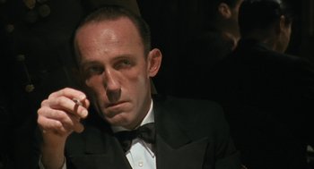 Movie still from “The Counterfeiters” (2007), directed by Stefan Ruzowitzky – A man in a tuxedo smoking a cigarette in the dark; Close Up shot, Low angle